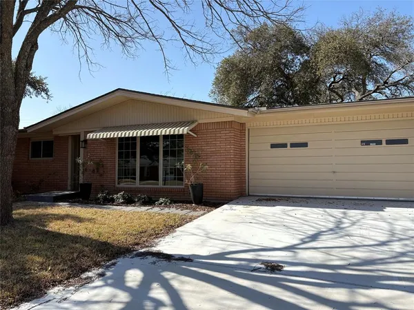 a front view of a house with yard outdoor seating and covered with green space