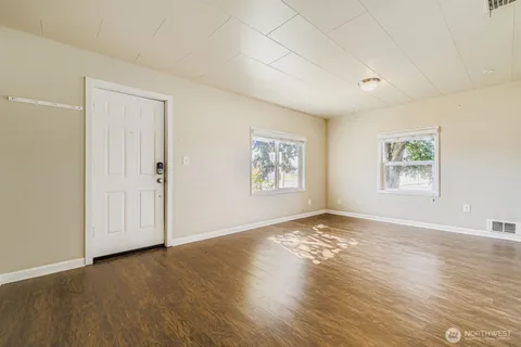 an empty room with wooden floor and window