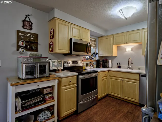 a kitchen with stainless steel appliances a stove microwave and sink