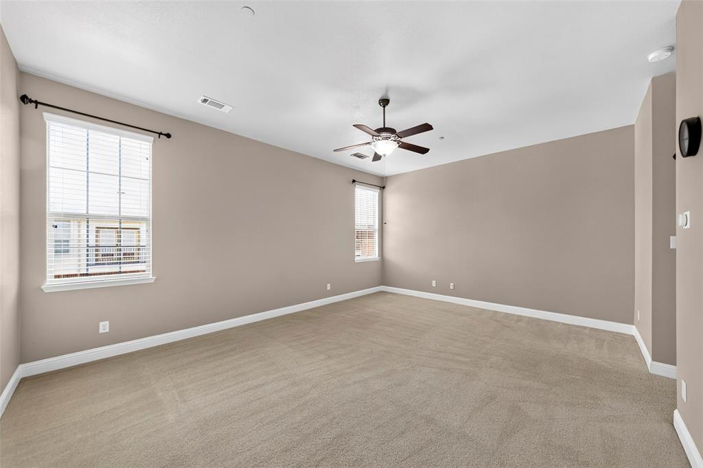 8607 Calvin Road Irving, TX 75063 - Photo 31 of 39 Spacious room featuring neutral carpeting, a ceiling fan, and multiple windows with blinds
