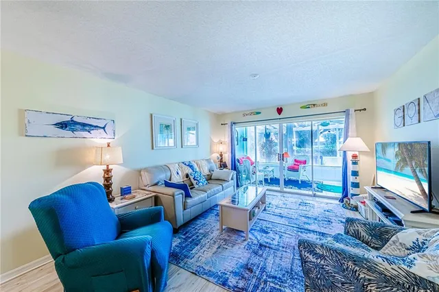 a living room with furniture flat screen tv and a large window