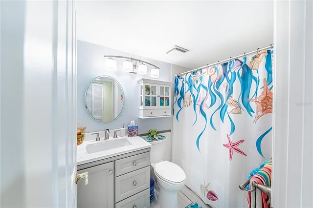 a bathroom with a sink mirror vanity and toilet