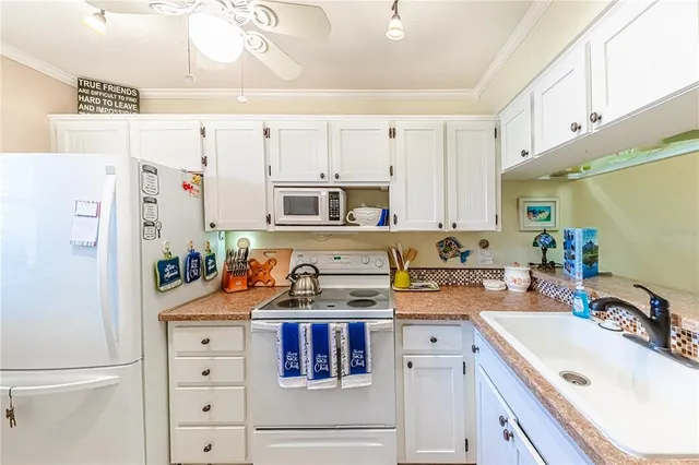 a kitchen with a sink a stove a refrigerator and cabinets