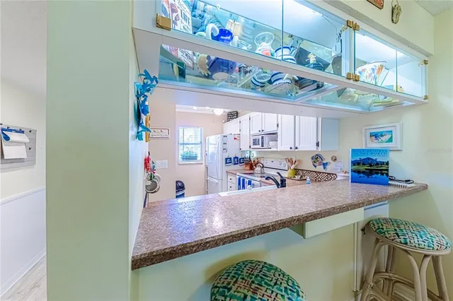 a kitchen with stainless steel appliances granite countertop a stove a sink and a dining table