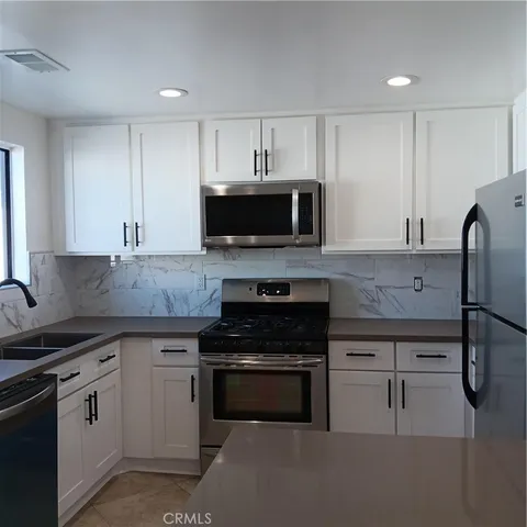 a kitchen with granite countertop a stove and a sink