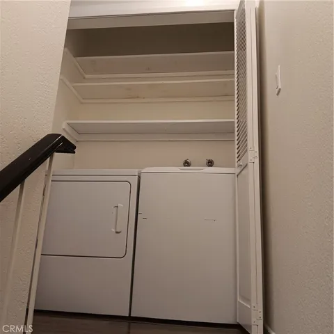 a view of a hallway with wooden floor and a bathroom