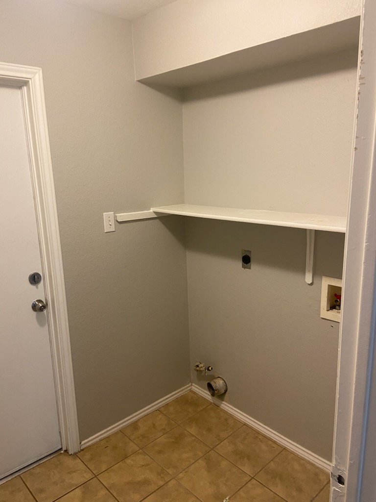 17616 Tobermory Drive Pflugerville, TX 78660 - Photo 12 of 14 Functional laundry nook with tiled flooring and convenient shelving.