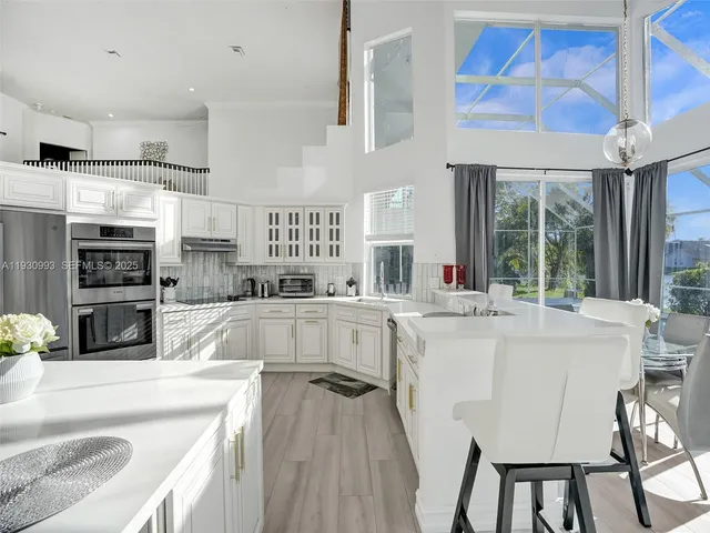 a kitchen with stainless steel appliances a refrigerator sink and cabinets