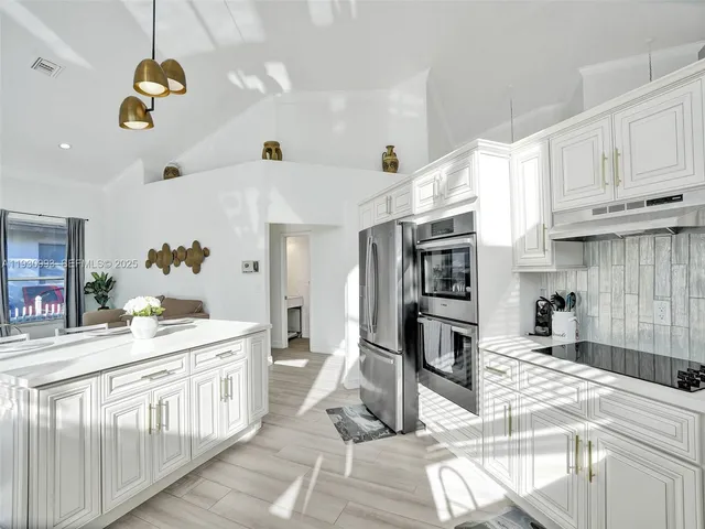 a dining room with furniture a chandelier and wooden floor