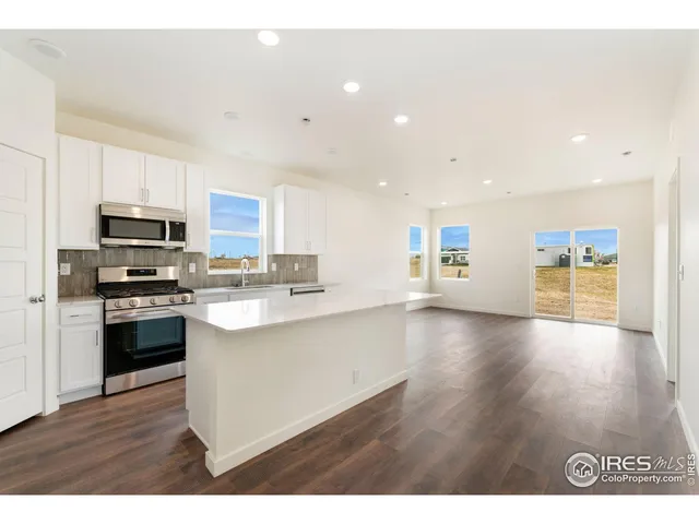 a kitchen with stainless steel appliances kitchen island granite countertop a stove a sink and a refrigerator