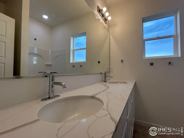 a bathroom with a granite countertop sink a mirror and a bathtub