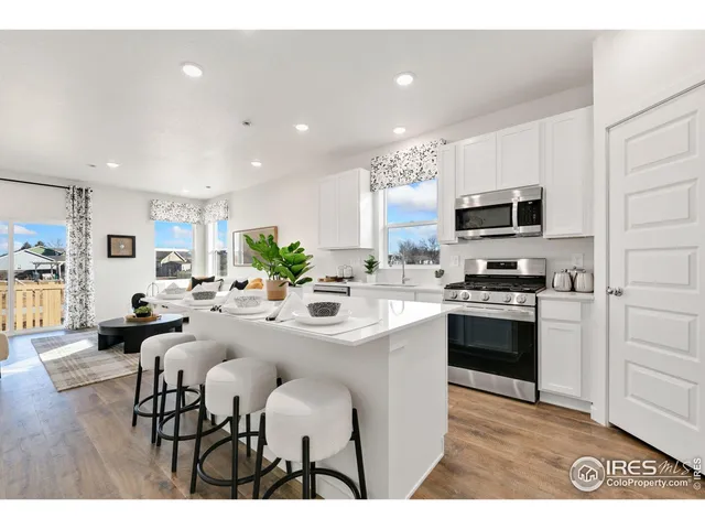 a kitchen with kitchen island white cabinets and stainless steel appliances