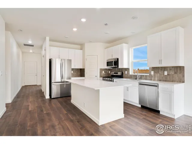 a kitchen with stainless steel appliances a refrigerator and a stove top oven