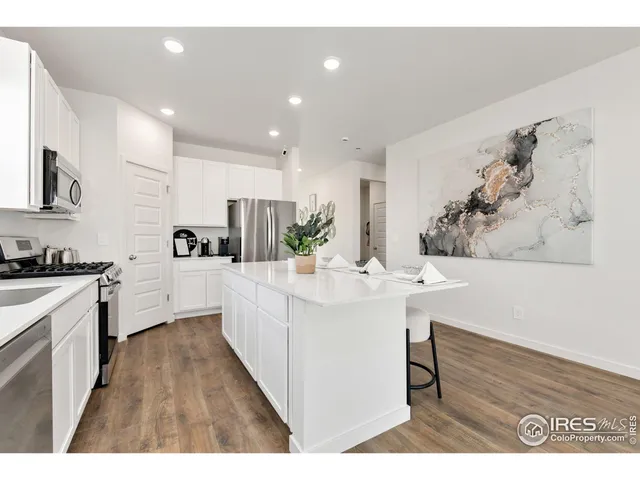 a kitchen with stainless steel appliances kitchen island sink stove and cabinets