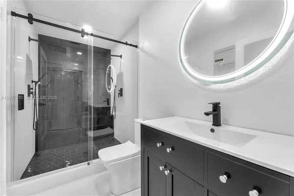 a bathroom with a sink a toilet and shower