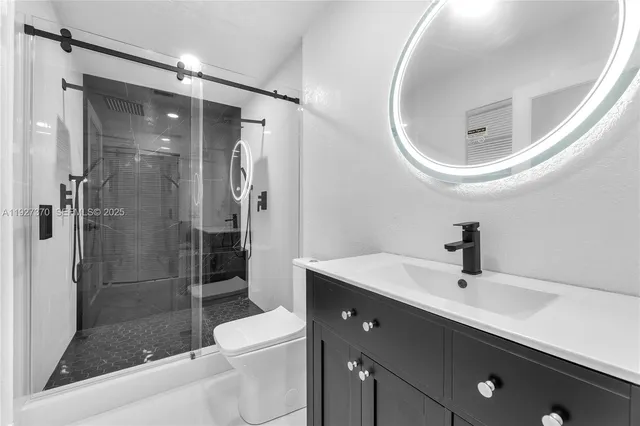 a bathroom with a sink a toilet and shower