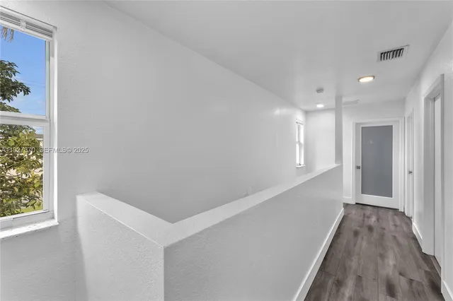 a view of hallway with wooden floor