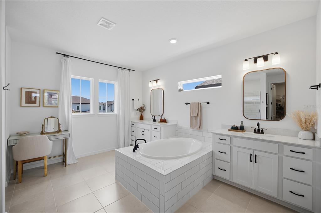13816 Sharp Hawk Drive Riverview, FL 33569 - Photo 38 of 76 a bathroom with a double vanity sink a mirror a bathtub and shower