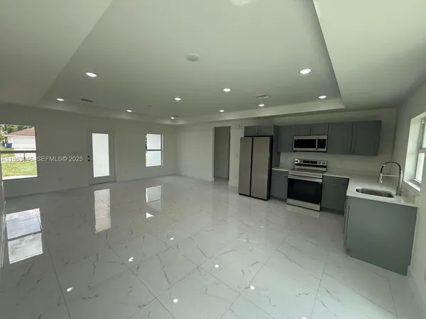 a kitchen with stainless steel appliances a refrigerator and a stove top oven