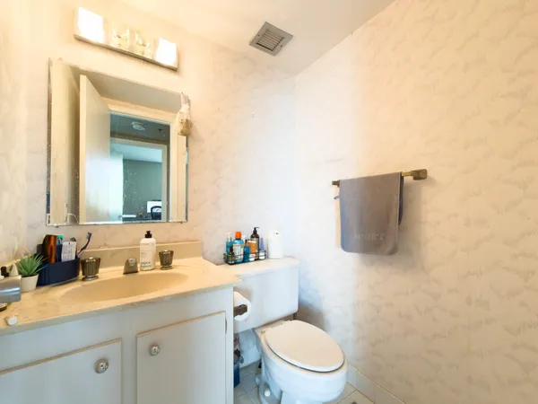 a bathroom with a sink mirror vanity and toilet