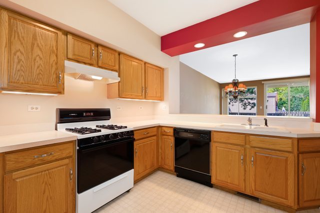 8171 Ripple Ridge Darien, IL 60561 - Photo 12 of 25 a kitchen with a sink stove and cabinets