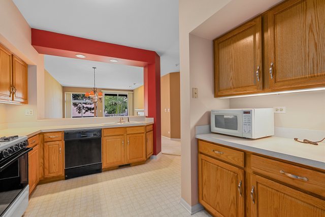 8171 Ripple Ridge Darien, IL 60561 - Photo 13 of 25 a kitchen with stainless steel appliances granite countertop a sink and dishwasher a stove top oven with wooden floor
