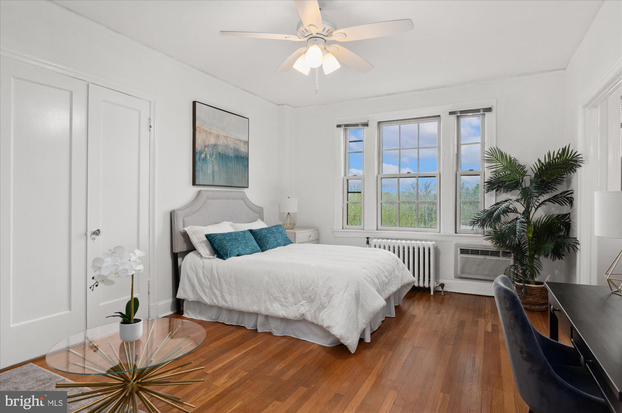 2032 Belmont Road Northwest, Unit 603 Washington, DC 20009 - Photo 3 of 16 a bedroom with a bed and wooden floor