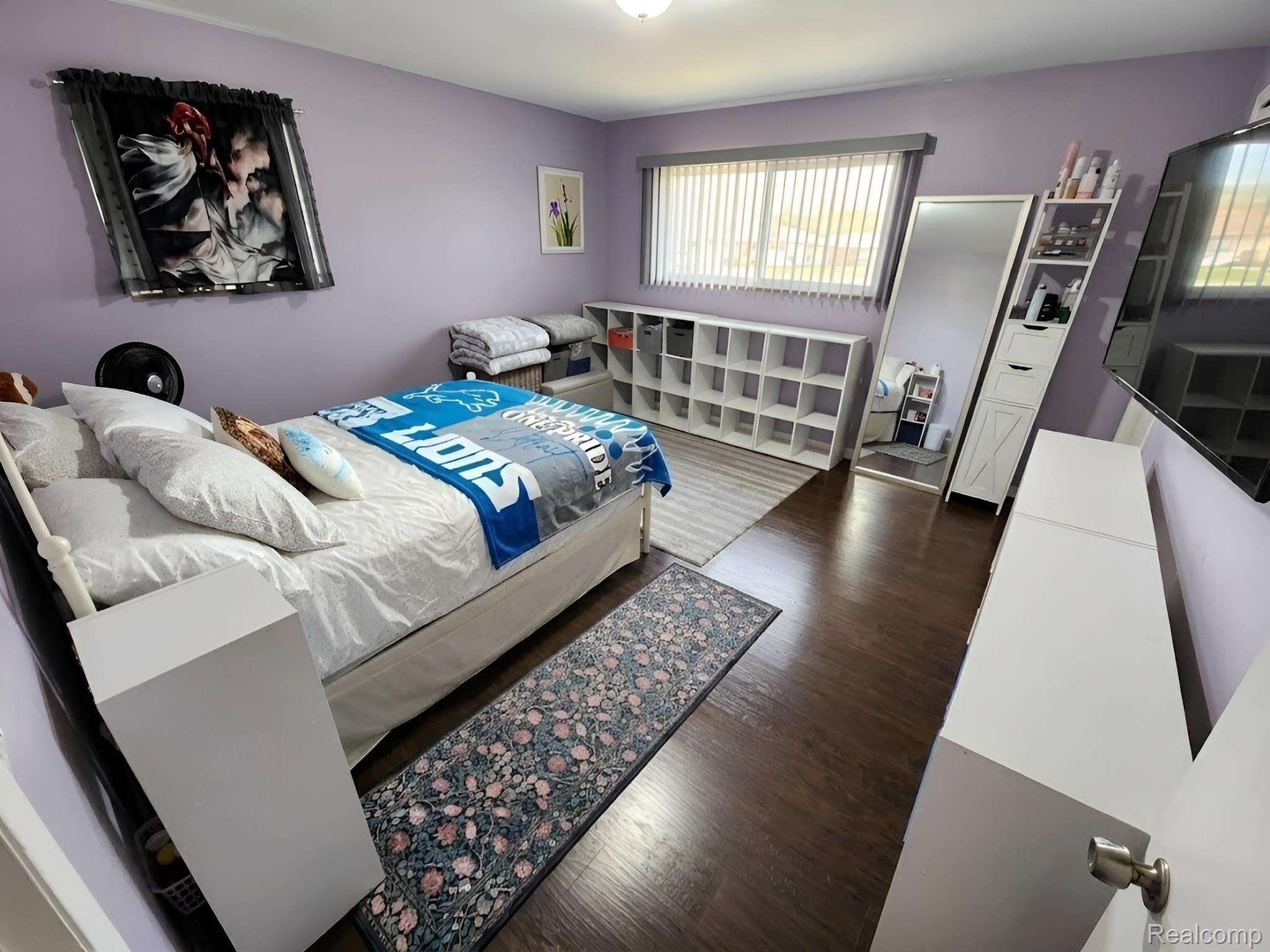 9921 Middlebelt Road, Unit 32 Livonia, MI 48150 - Photo 7 of 11 Bedroom featuring wood-finish flooring, a window with horizontal blinds, and a built-in wall-mounted television