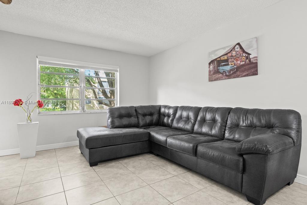 351 Cambridge Road, Unit 208 Hollywood, FL 33024 - Photo 11 of 35 a living room with furniture and a window