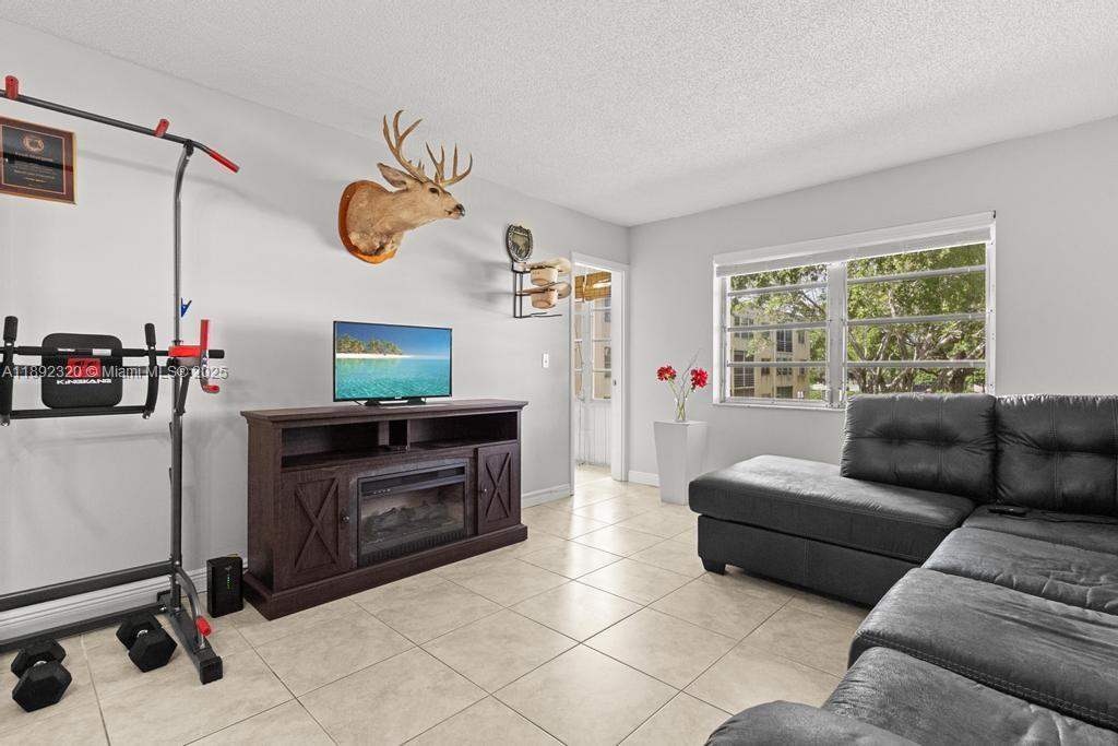 351 Cambridge Road, Unit 208 Hollywood, FL 33024 - Photo 12 of 35 a living room with furniture a window and a flat screen tv