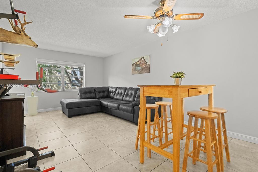 351 Cambridge Road, Unit 208 Hollywood, FL 33024 - Photo 13 of 35 a living room with furniture and a chandelier
