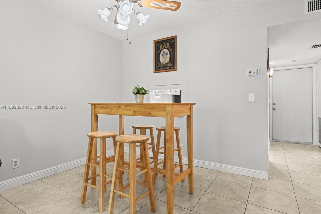 351 Cambridge Road, Unit 208 Hollywood, FL 33024 - Photo 14 of 35 a view of a dining room with furniture and chandelier