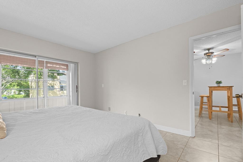 351 Cambridge Road, Unit 208 Hollywood, FL 33024 - Photo 16 of 35 a bedroom with a bed and a table