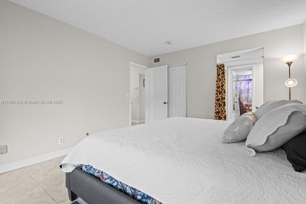 351 Cambridge Road, Unit 208 Hollywood, FL 33024 - Photo 17 of 35 a bedroom with a bed and a chair