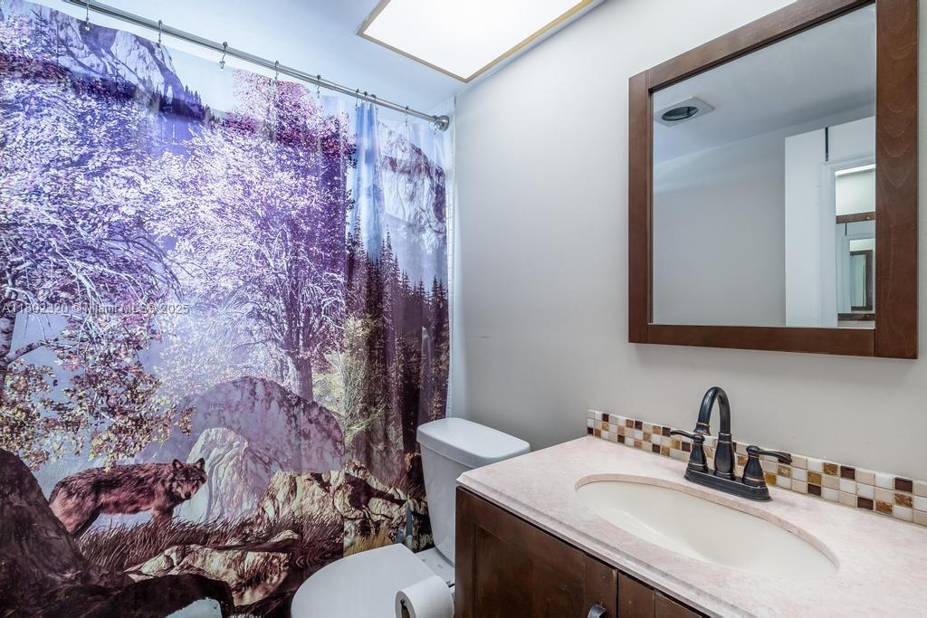 351 Cambridge Road, Unit 208 Hollywood, FL 33024 - Photo 20 of 35 a bathroom with a sink vanity mirror and toilet