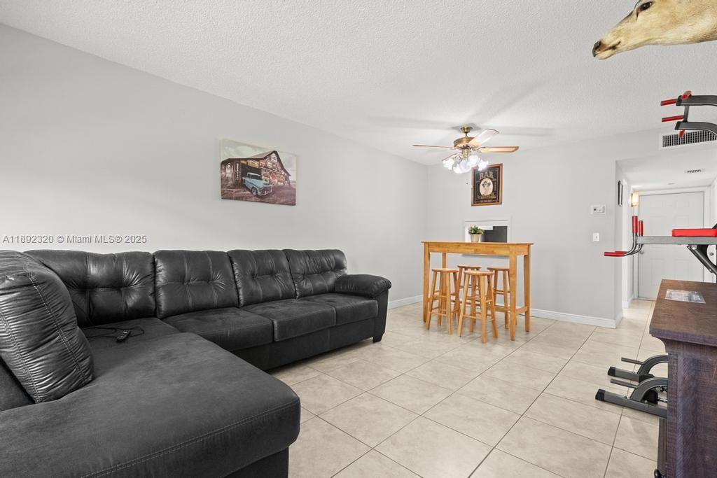 351 Cambridge Road, Unit 208 Hollywood, FL 33024 - Photo 3 of 35 a living room with furniture a dining table and a piano table