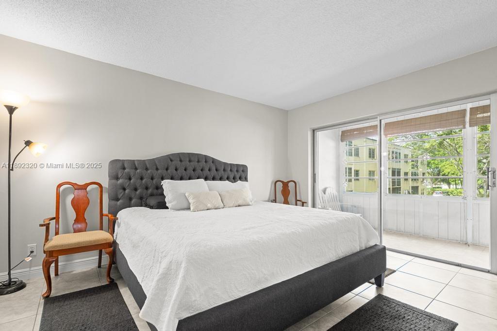 351 Cambridge Road, Unit 208 Hollywood, FL 33024 - Photo 4 of 35 a bedroom with double bed and a large window