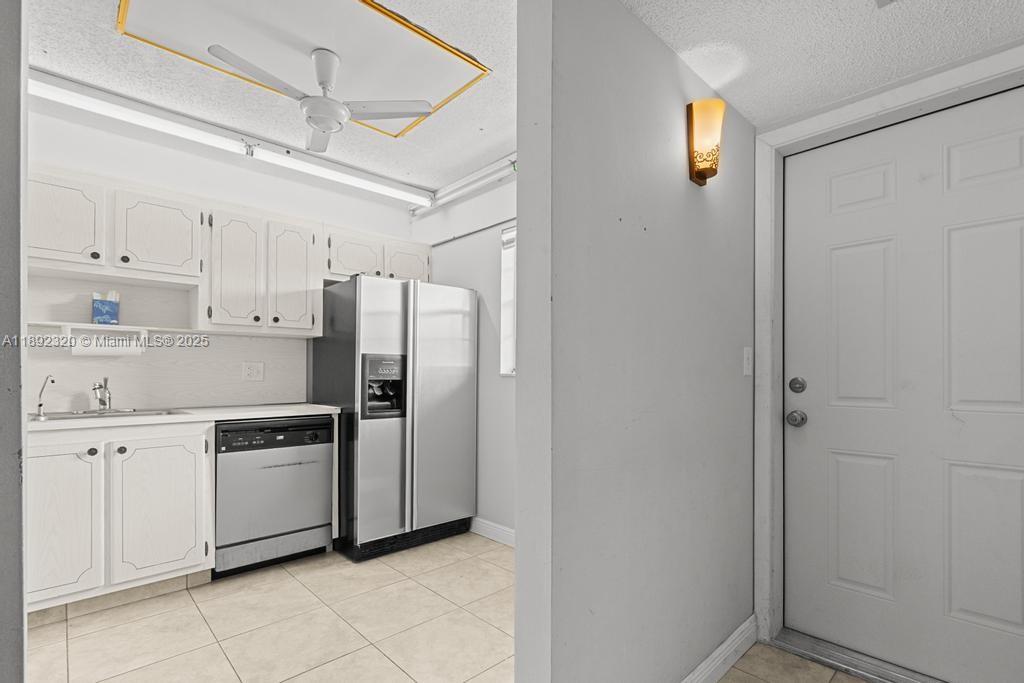 351 Cambridge Road, Unit 208 Hollywood, FL 33024 - Photo 7 of 35 a kitchen with stainless steel appliances granite countertop a refrigerator and a sink