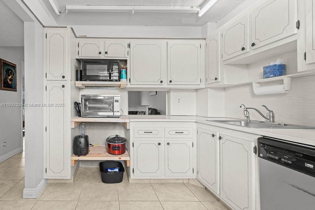 351 Cambridge Road, Unit 208 Hollywood, FL 33024 - Photo 8 of 35 a kitchen with white cabinets and white appliances