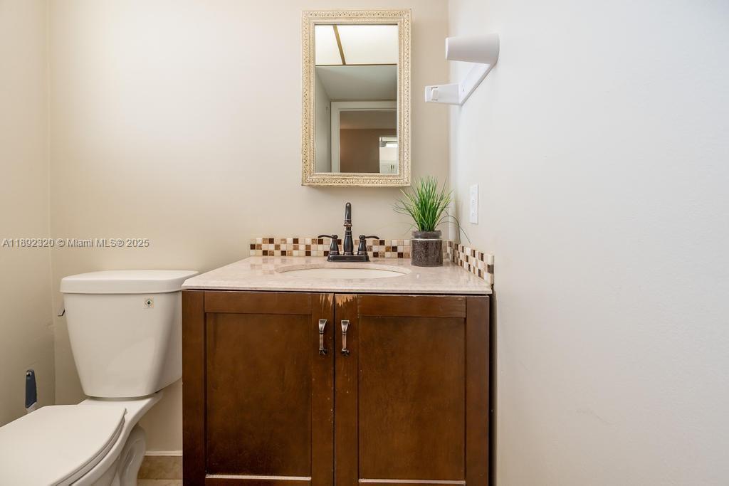 351 Cambridge Road, Unit 208 Hollywood, FL 33024 - Photo 10 of 35 a bathroom with a sink toilet and mirror