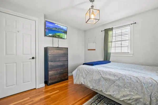 a bedroom with a bed and a painting on the wall