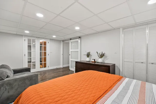 a bedroom with a large bed and wooden floor