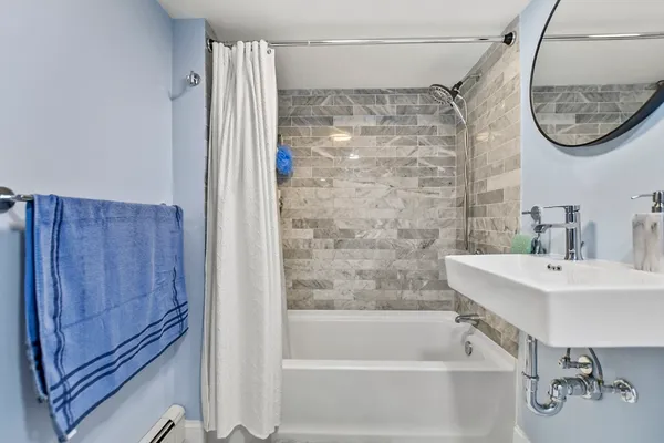 a bathroom with a shower a mirror and a sink