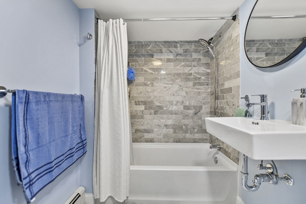 118 1/2 Market Street, Unit 118 1/2 Amesbury, MA 01913 - Photo 21 of 37 a bathroom with a shower a mirror and a sink
