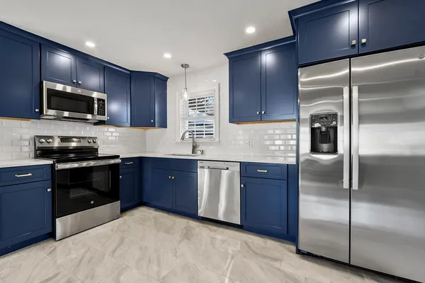 a kitchen with granite countertop stainless steel appliances and wooden cabinets