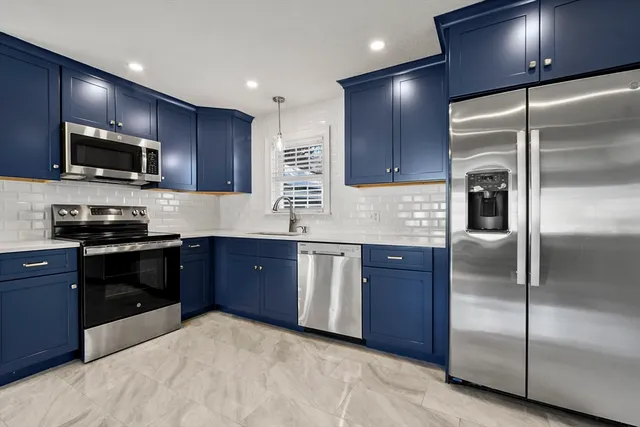 a kitchen with granite countertop stainless steel appliances and wooden cabinets