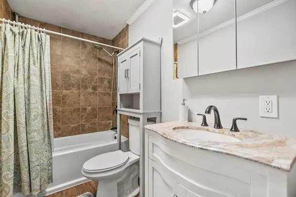 a bathroom with a granite countertop sink toilet and shower