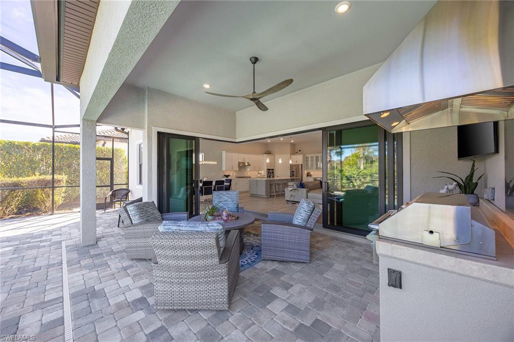 9309 Surfbird Court Naples, FL 34120 - Photo 28 of 45 View of patio / terrace with area for grilling, a lanai, a sunroom, and a ceiling fan