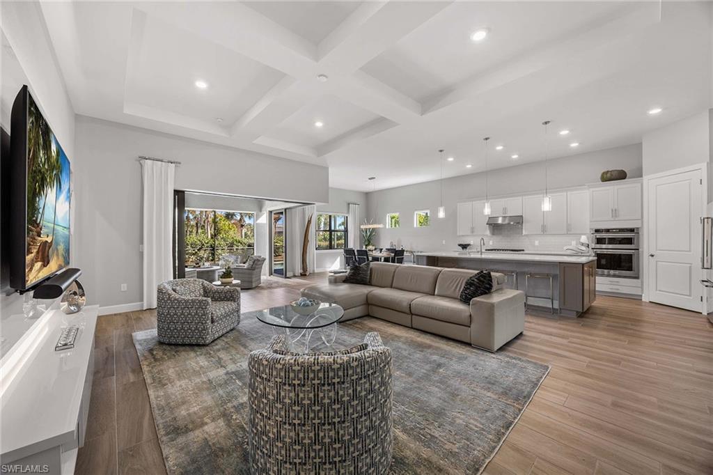 9309 Surfbird Court Naples, FL 34120 - Photo 7 of 45 Living room with coffered ceiling, beamed ceiling, recessed lighting, and light wood finished floors