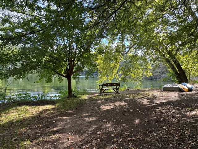 a view of a lake with outdoor seating and trees